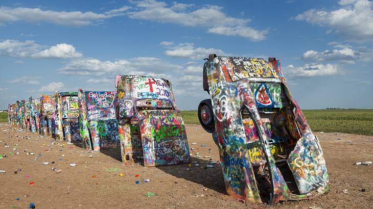 Graffiti sprayed cars half buried nose-down in the ground