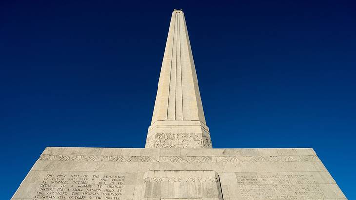 An octagonal limestone column with a base and dark blue sky in the background