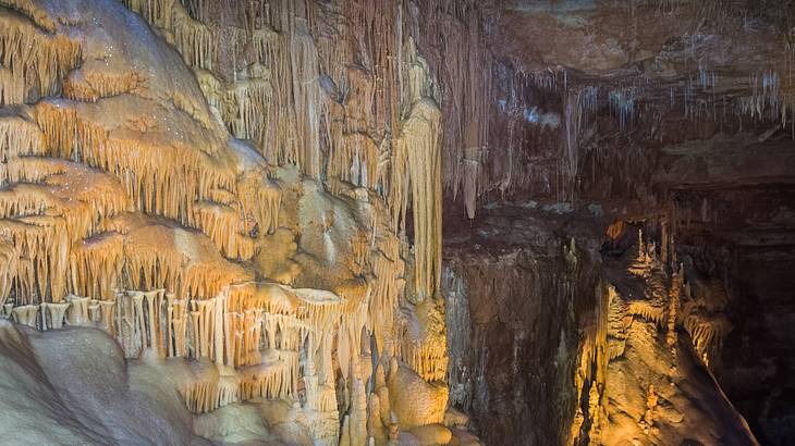 Up-close shot of stalactites and stalagmites in an illuminated cave