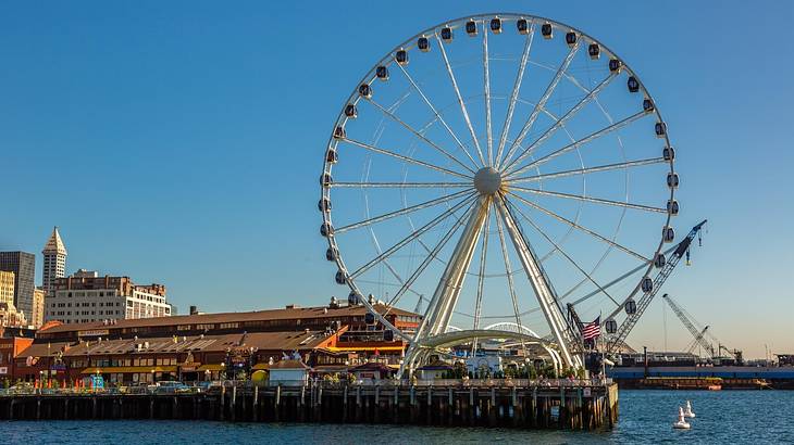 A Ferris wheel on a pier with water around it
