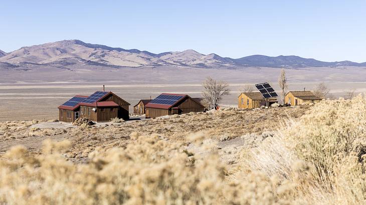 Abandoned houses in the desert with mountains in the background