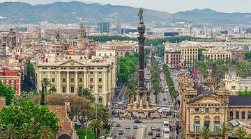 Aerial view of a city with a column and buildings fading into background of mountains