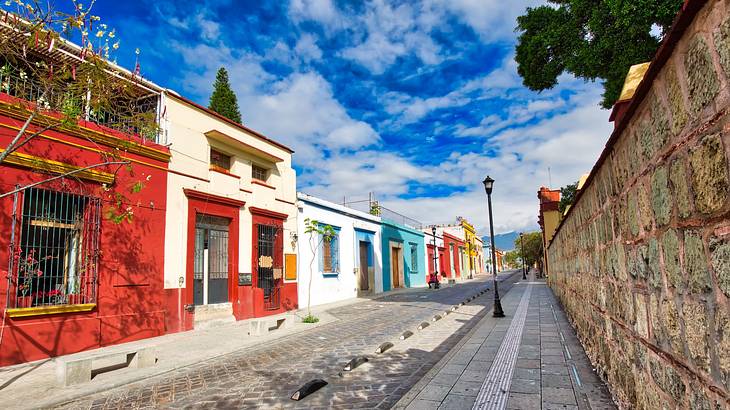 Colonial buildings in red, white, and blue lined along a cobblestone street