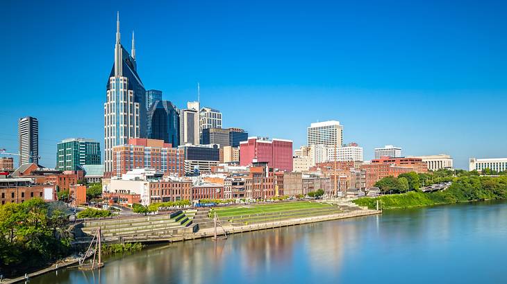 A river with buildings in the background against sunny blue skies