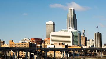 A city skyline with tall and short buildings and a bridge in front, on a nice day