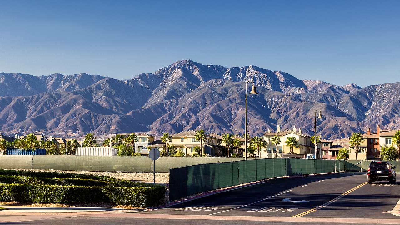 A quiet residential street in a suburb with a barren mountain range at the back