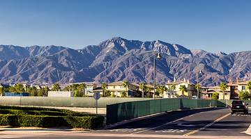 A quiet residential street in a suburb with a barren mountain range at the back