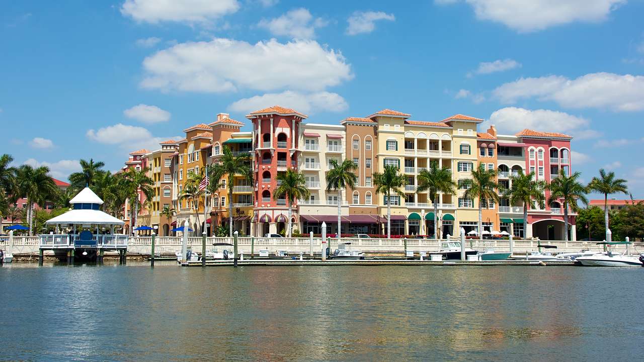 Colorful tropical buildings overlooking palm trees and small boats docked on water