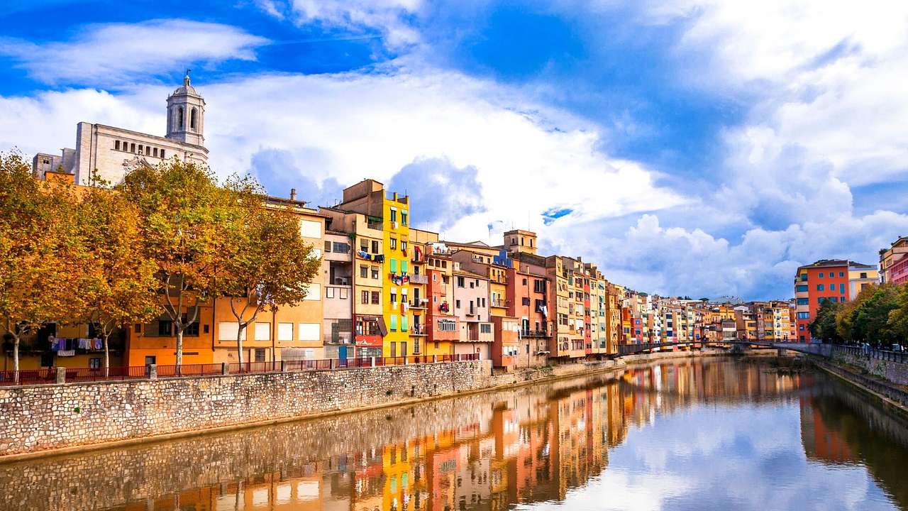 Multi-colored buildings overlooking a canal under a partly cloudy sky