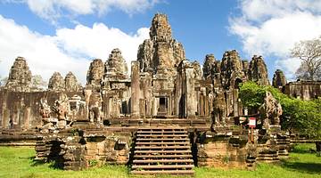 An ancient temple building with rock towers surrounded by greenery