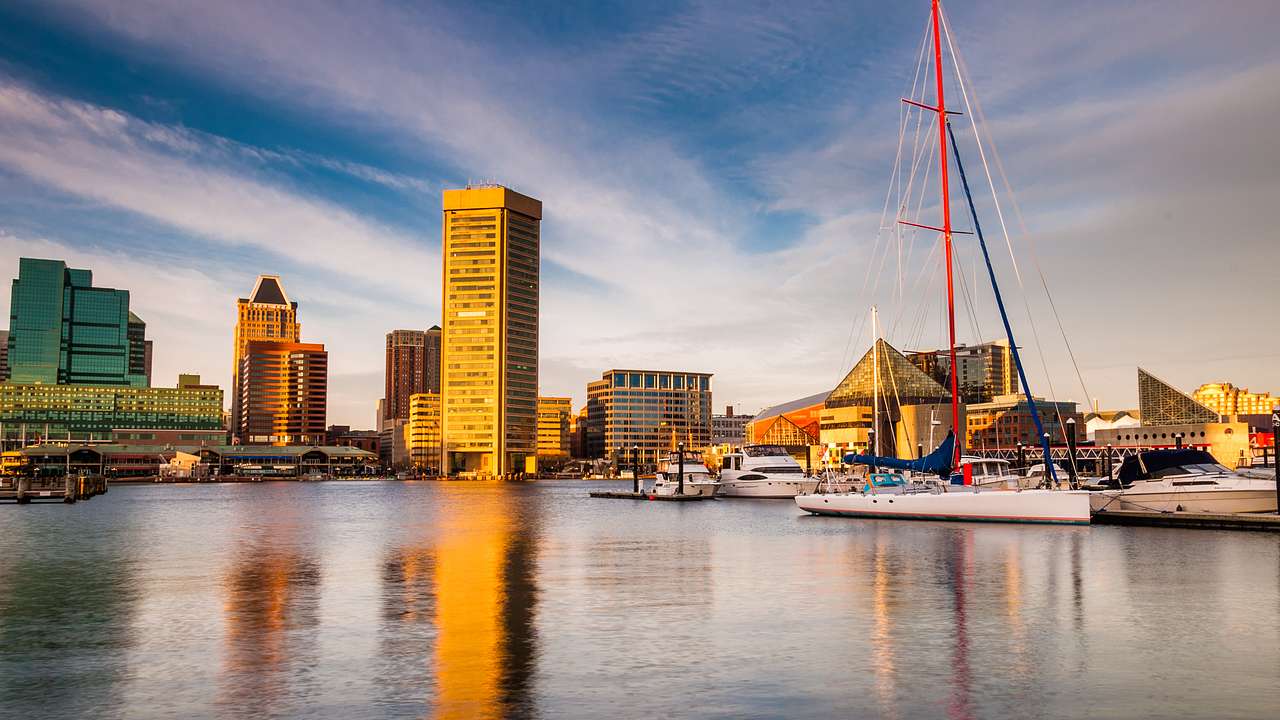 An inner harbor with sailboats and a mast on the right and buildings on the left