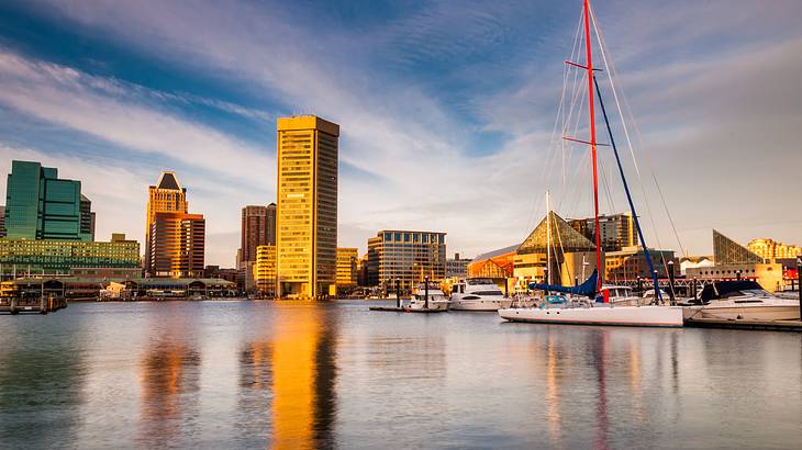 An inner harbor with sailboats and a mast on the right and buildings on the left