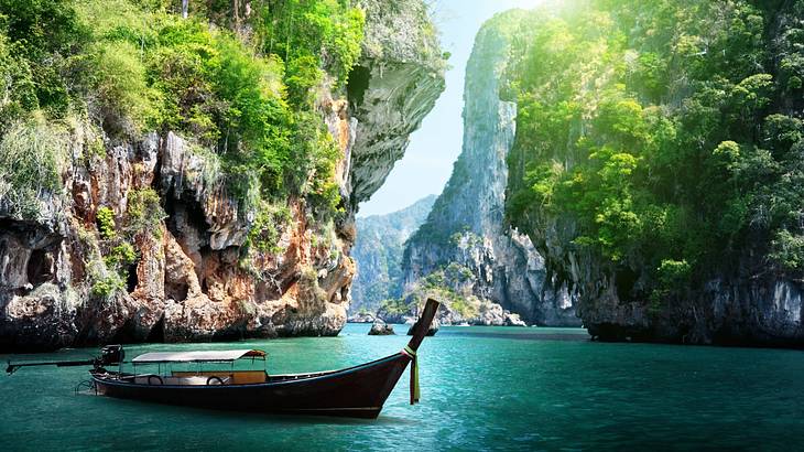 Steep cliffs with green foliage on the cliffside overlooking turquoise clear water