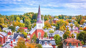 Colorful foliage, a church with a tall spire, and buildings from above